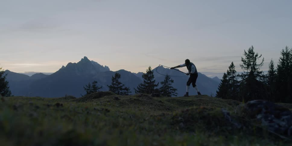 A man waves a whip through the air outdoors
