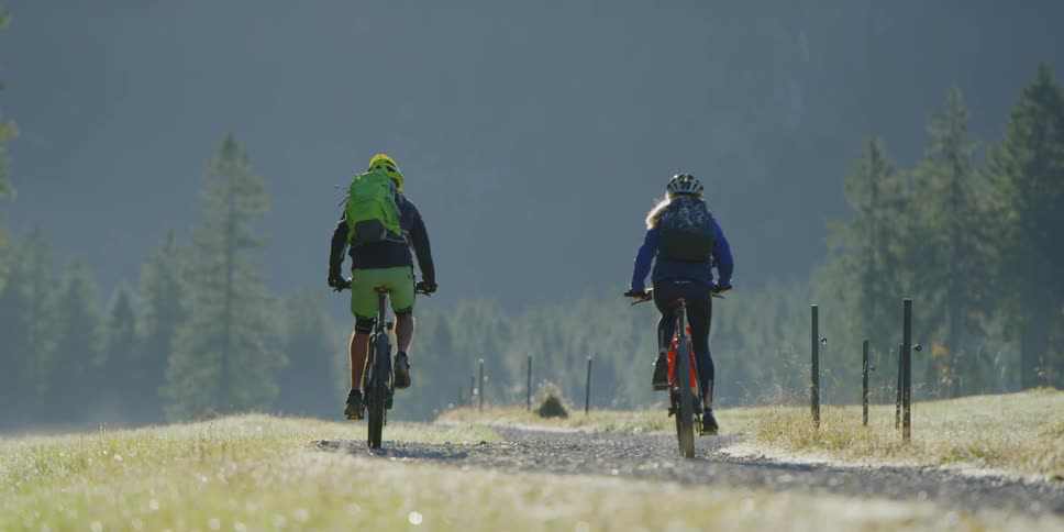 A couple of cyclist riding bicycles down a rural road