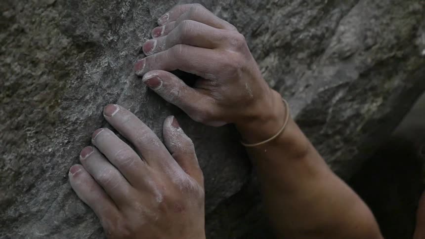 Dusty hands clasping a small rock ledge
