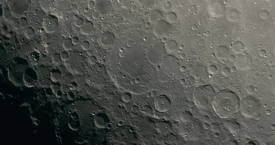 Large and small craters on a close up view of the Moon