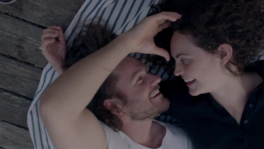 A male and female laying next to each other on a blanket