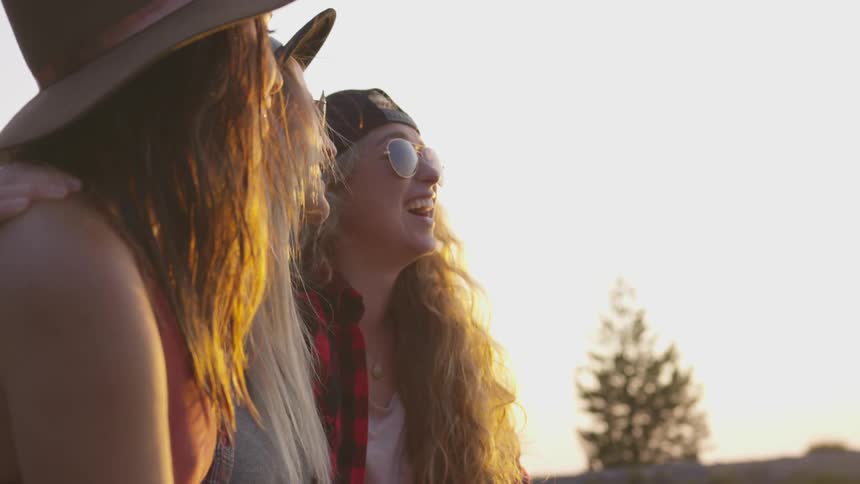 Three women stand together laughing