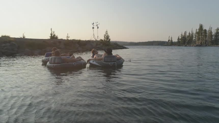 People float on a lake in inner tubes