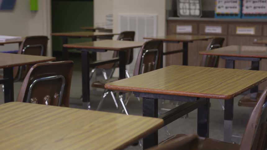 Empty desks are in a classroom