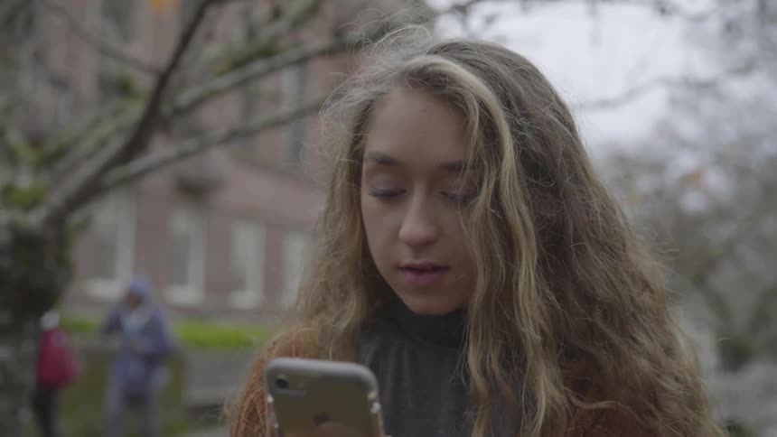 Woman takes selfie while standing outside