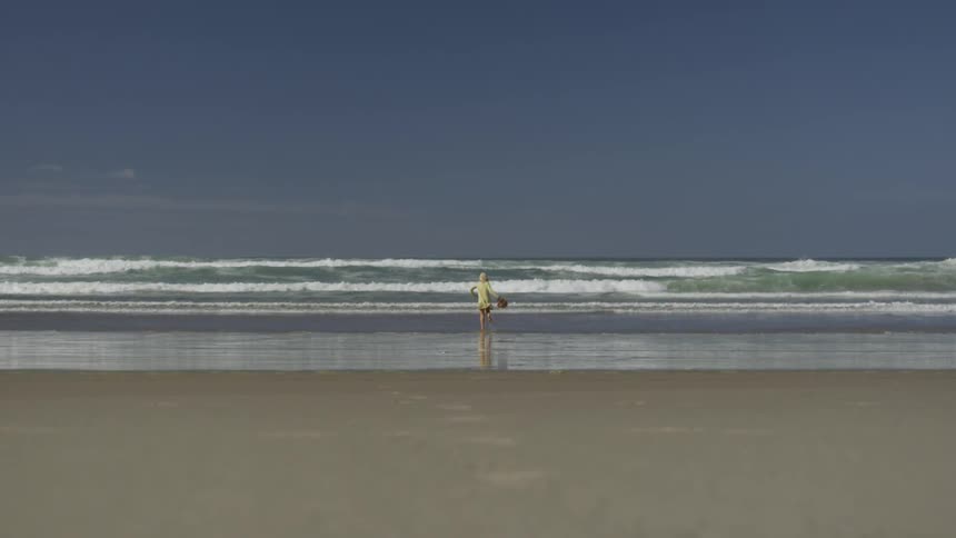 A child runs across a beach