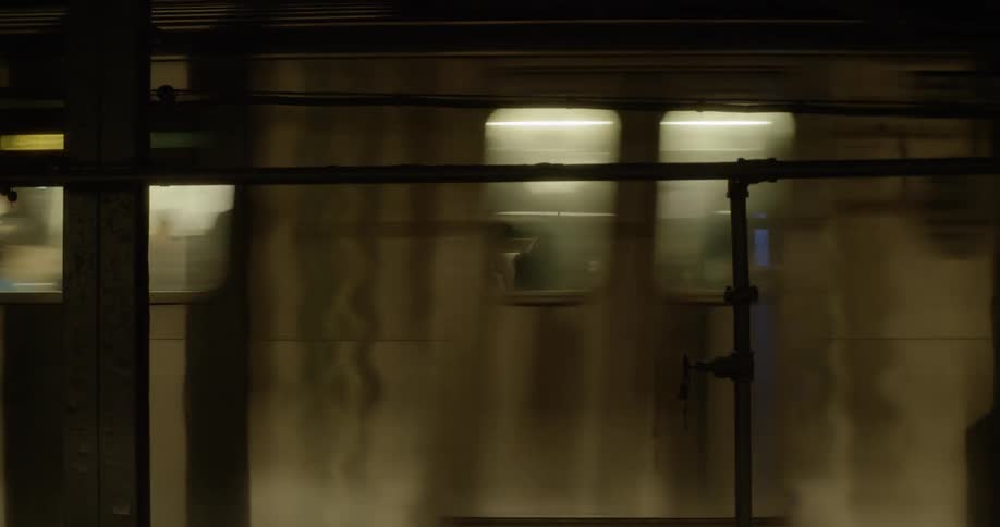 A subway train passes through a station at night