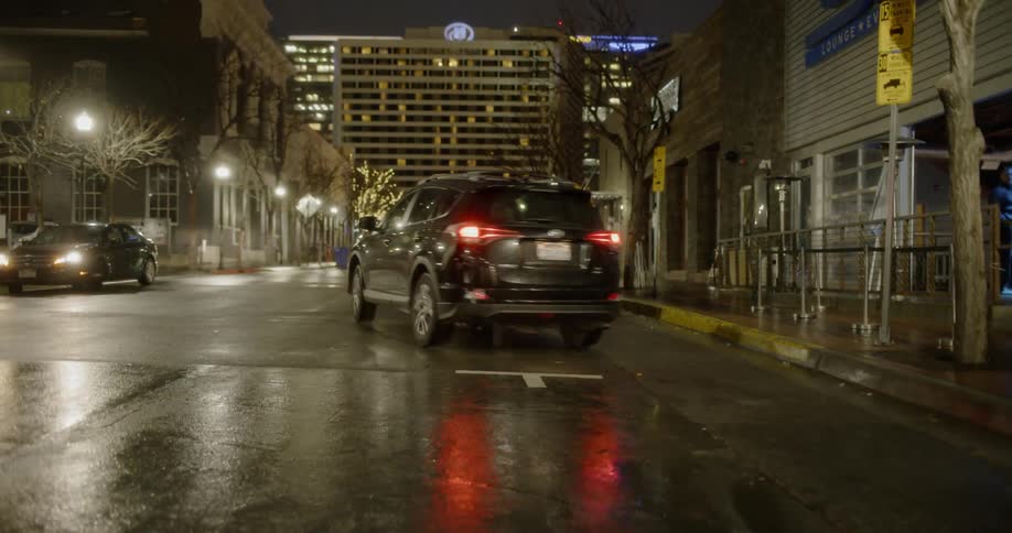 A toyota accelerates quickly from a parking space at night