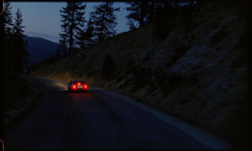 A car driving in a dark winding road