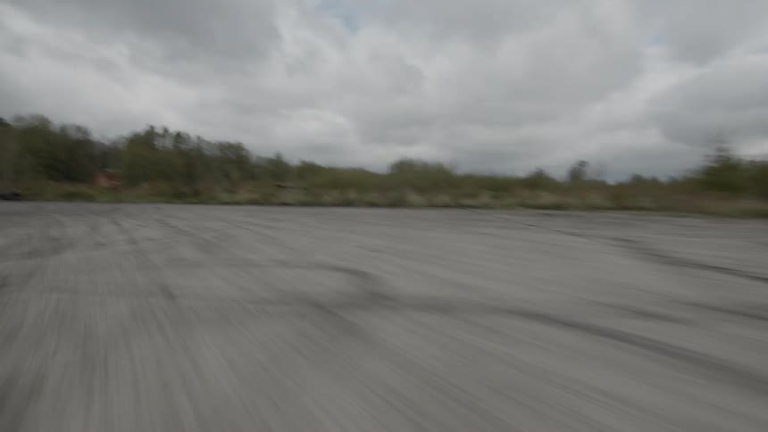 Car drives along the race track on a cloudy day