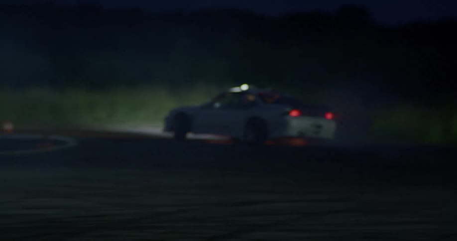 A white car drift racing at nighttime