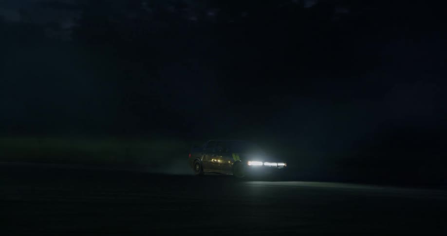 A car drifts in from light to darkness