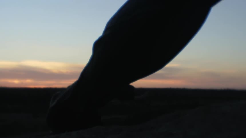 A cloak blows in the wind behind a person