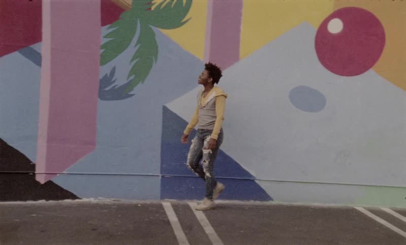 Teenager posing and pacing in front of mural