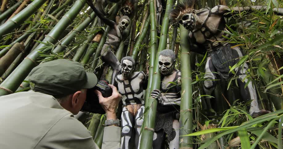 Photographer takes a picture of painted tribal men