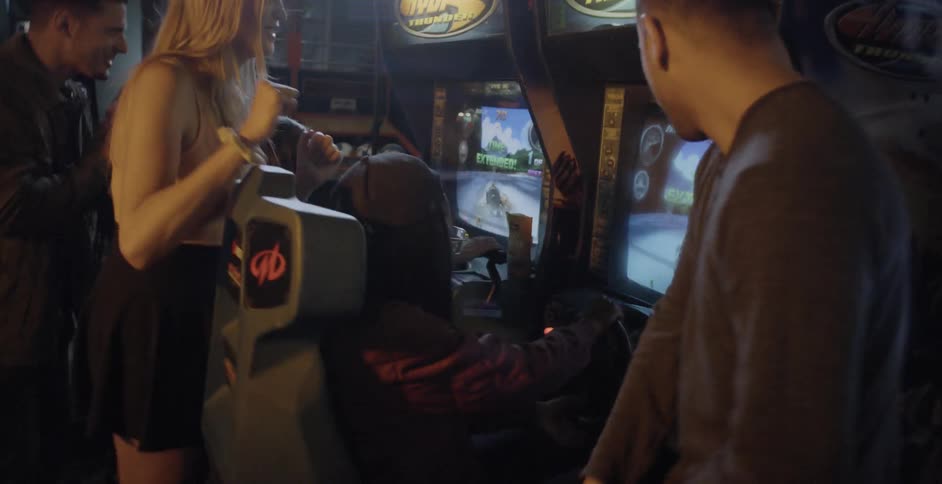 A group of people play games in an arcade