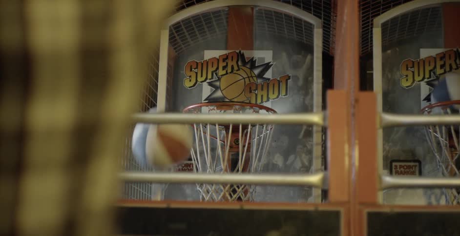A person throws a basketball at a basketball hoop