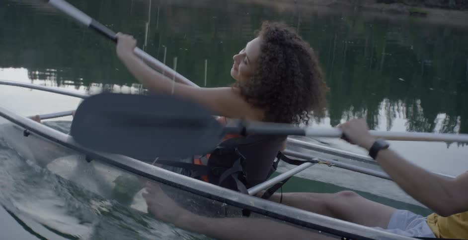 A man and woman are rowing a small boat together