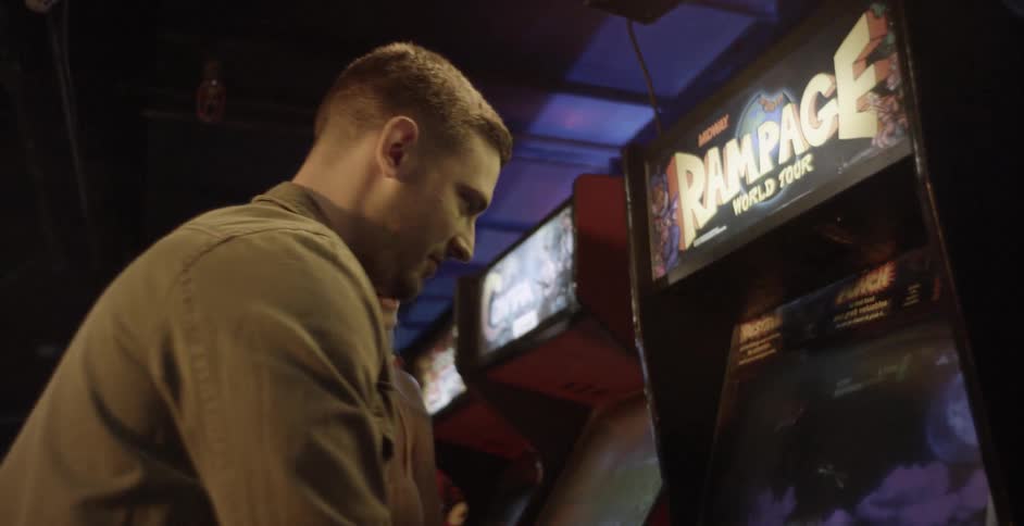 A man and woman play an arcade game