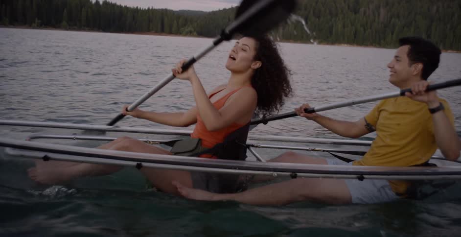 A couple paddle a glass bottom canoe