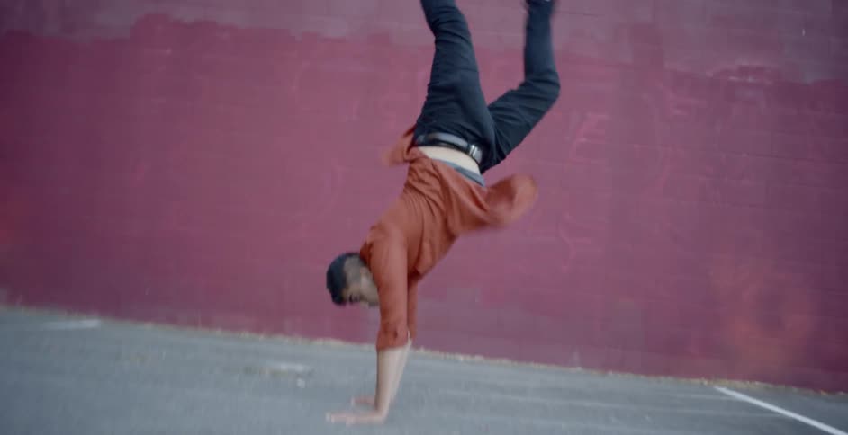 A young male on the pavement break dancing