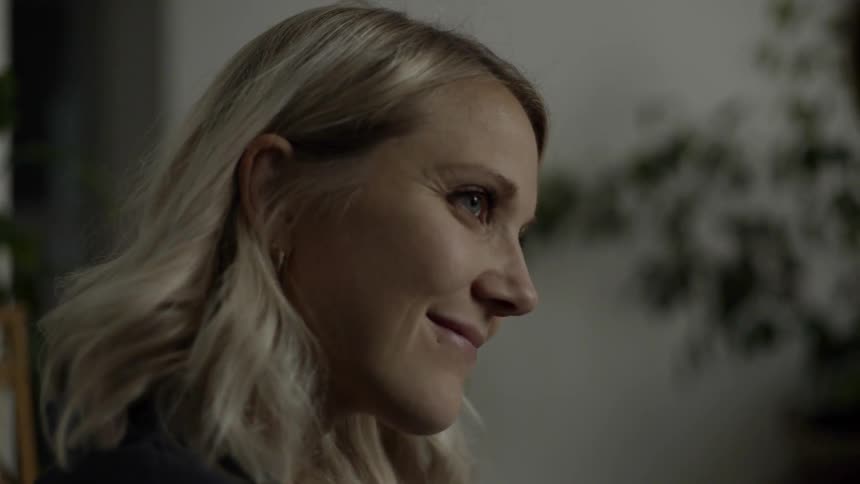 A woman inside sitting down smiling