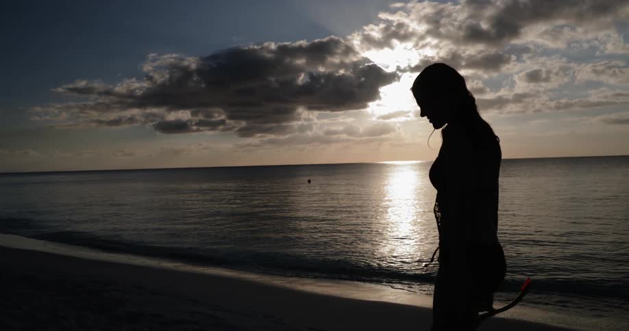 A woman walking down a beach