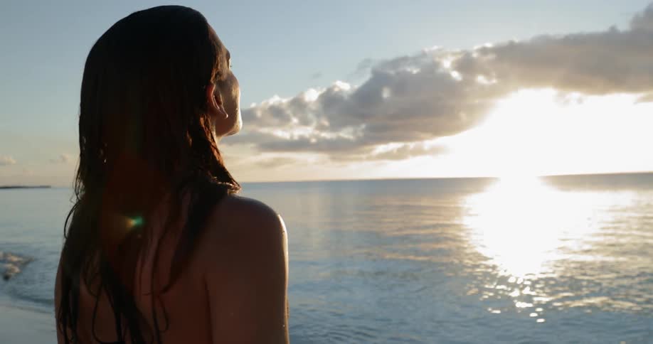 Woman basks in sunlight on beach