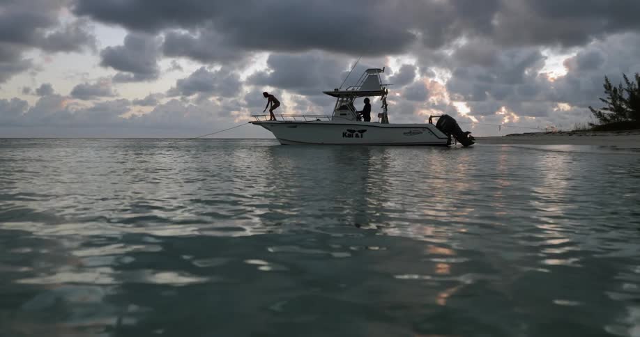 A person coming to sit on the deck of a boat on a cloudy evening