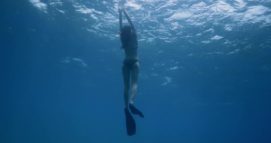 A woman snorkeling goes under the water