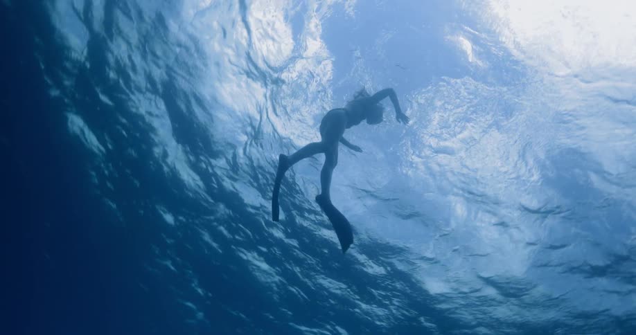 A female snorkeler swimming near the surface of a body of water