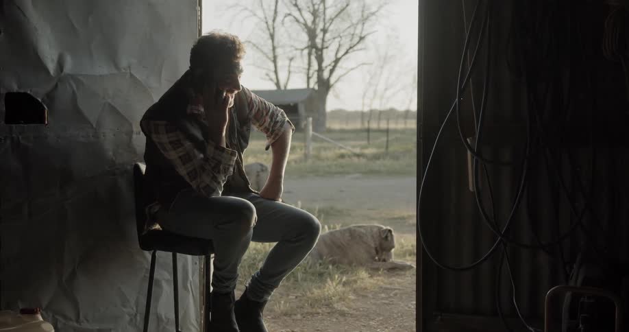 Man talking on the phone while sitting in a chair next to his dog