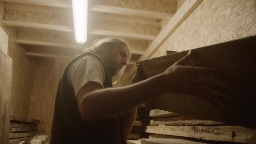 A man lifting pieces of wood onto a shelf