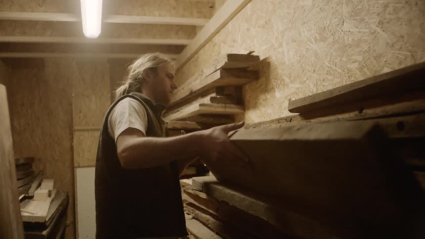 A man stacks wooden planks