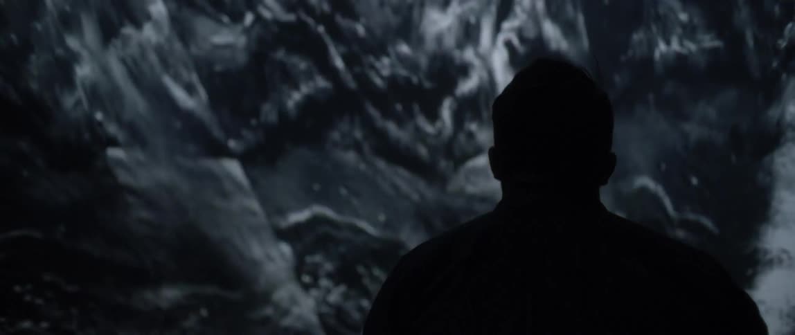 A male looking at a screen that has water running over rocks