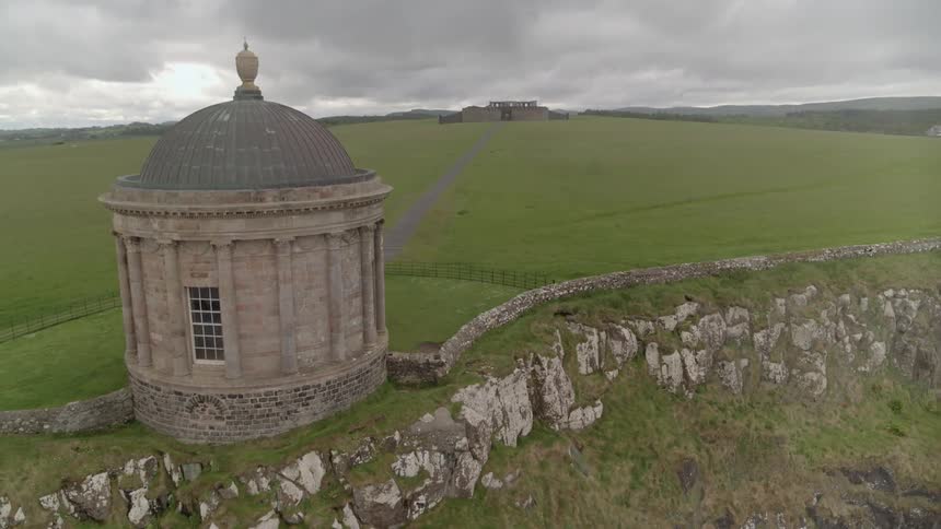 A domed building on a cliff at the edge of a field