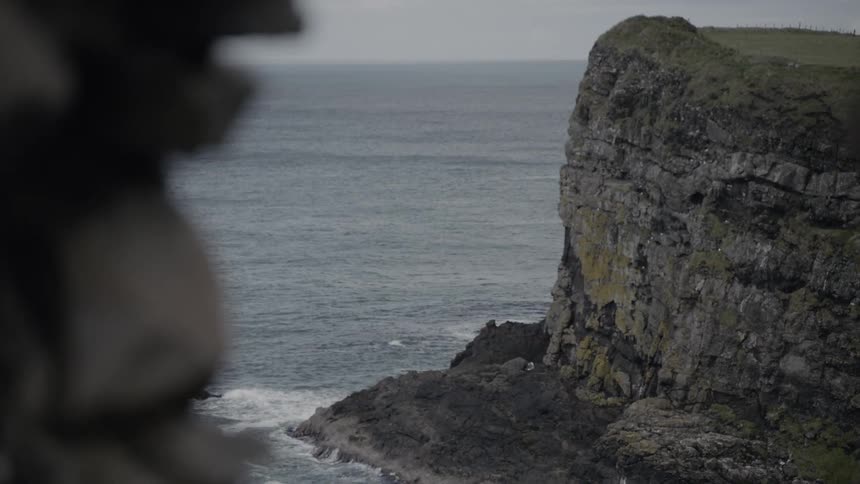 Rocky cliffs loom over the ocean