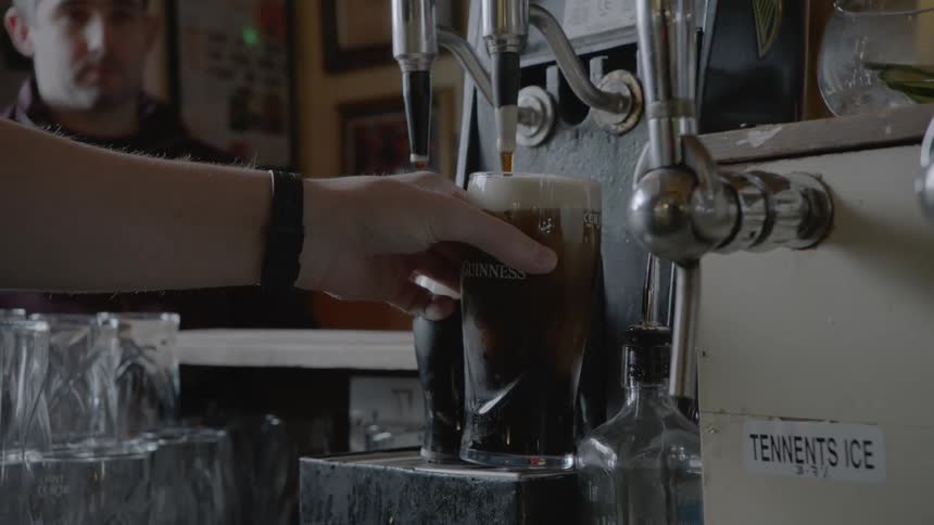 A male pouring a liquid from a tap