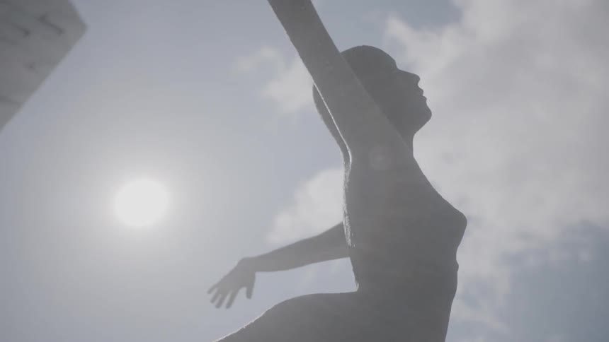 A statue rises into the cloudy sky