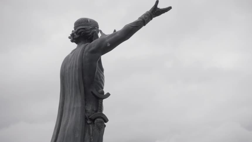 Statue of warrior under cloudy sky
