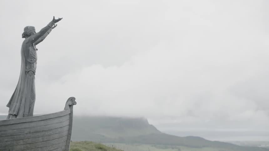 A statue of a person on a boat with their hands up