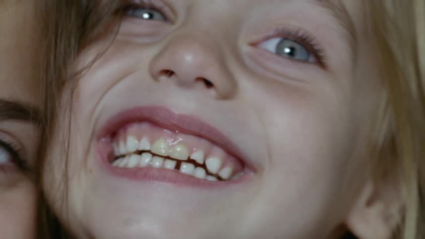 Two little girls put their faces together and smile