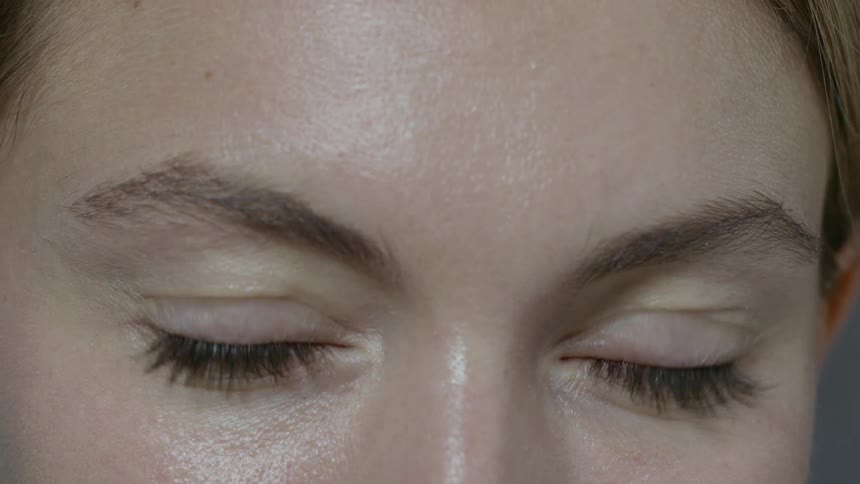 A woman is blinking her eyes