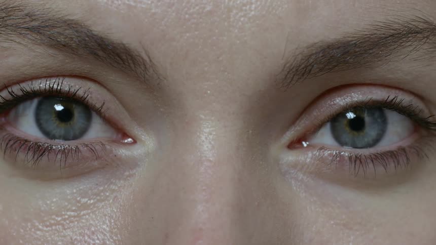 A blue eyed white woman opening her eyes and looking into the camera