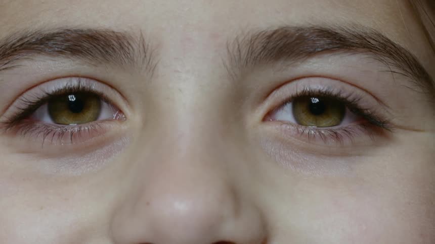 A child with hazel eyes staring and blinking