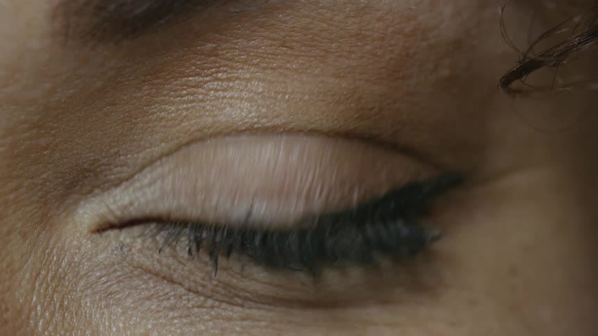 A brown eyed black woman blinking while looking into the camera