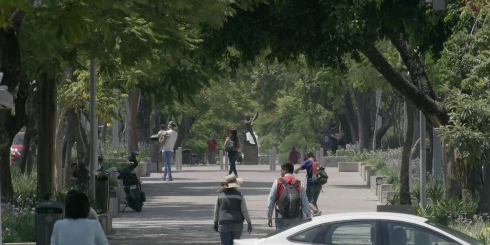 People walk along wide sidewalk