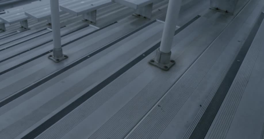 A man runs up the stairs in the bleachers
