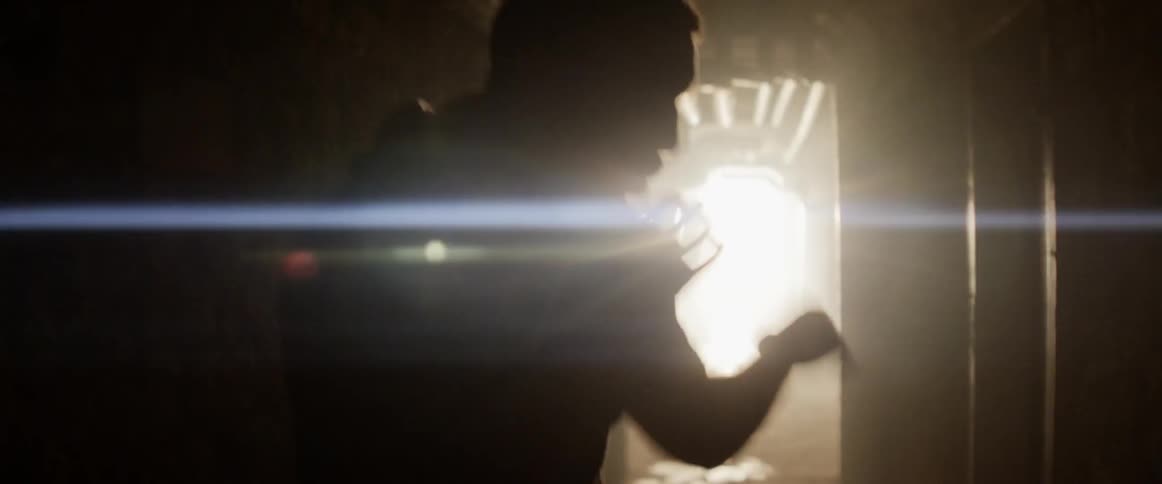 A man inside shadow boxing with lights in the background