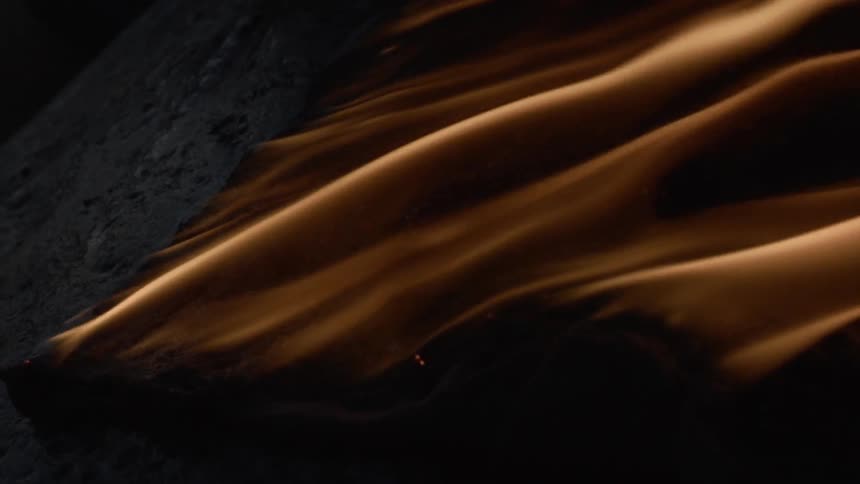 A fire burns and seems to slide over wood